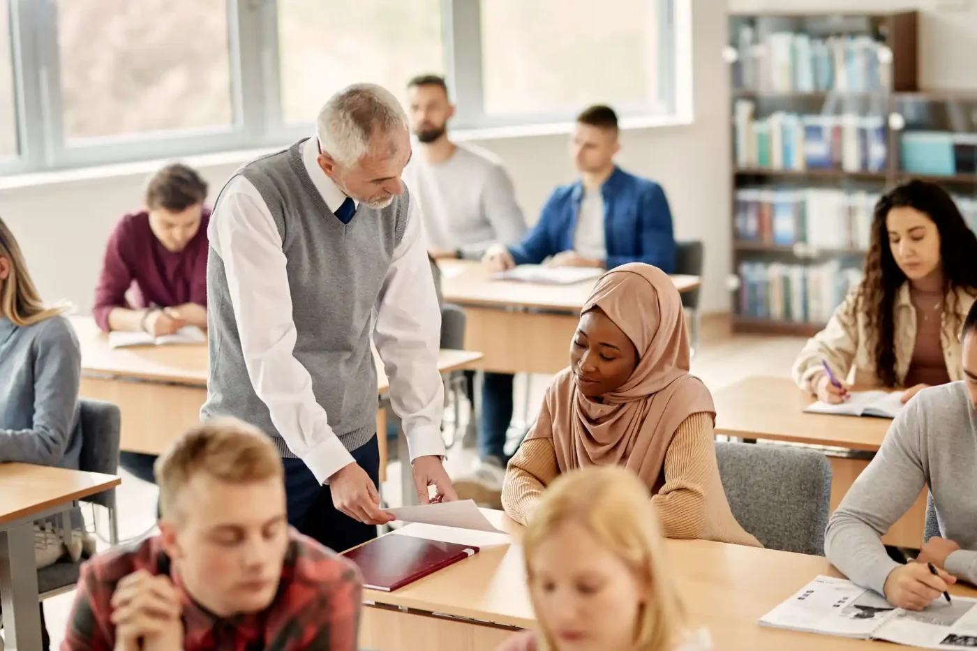 A teacher point textbook to a student during class